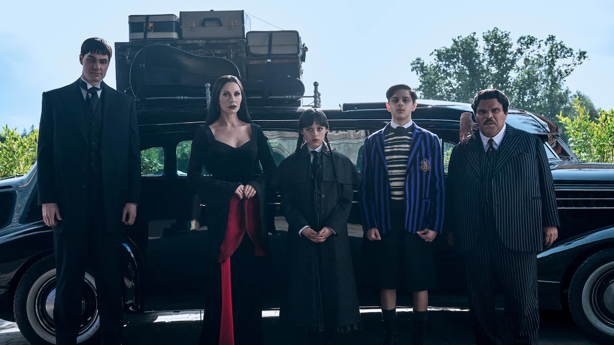 Catherine Zeta-Jones as Morticia Addams with the Addams family outside their home in Wednesday Season 2